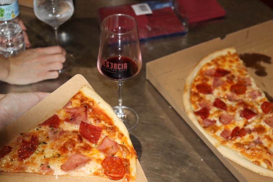Pizza y copa de vino tinto en un evento